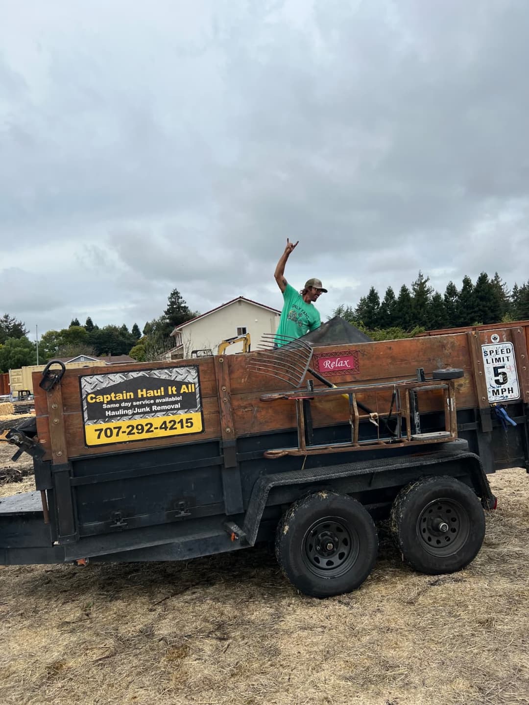Worker standing in hauling trailer after debris removal job.